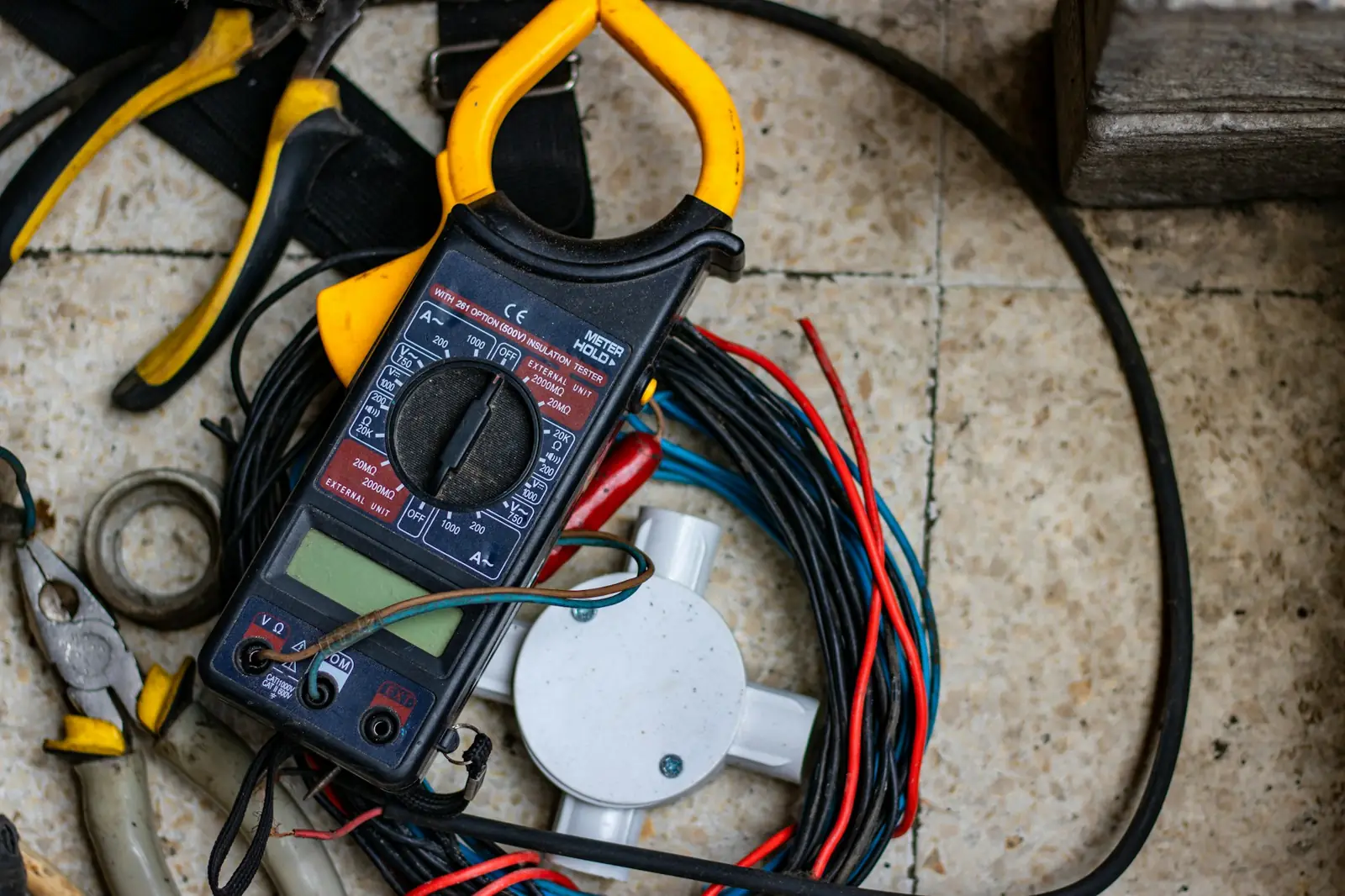 クランプメーターと電線などの工具（Unsplashの写真）